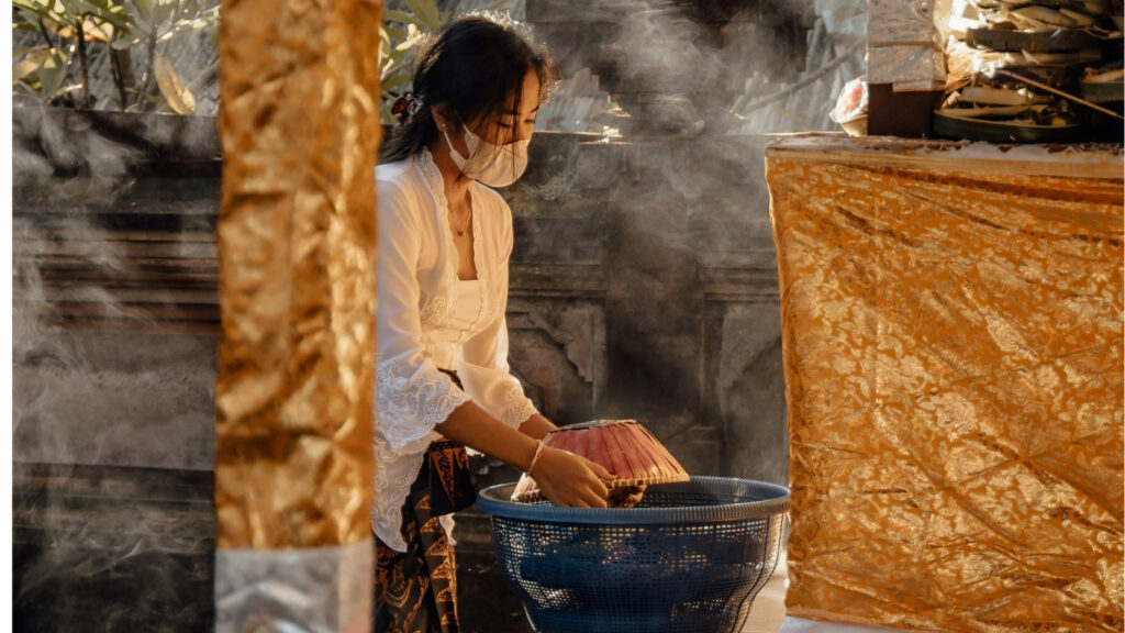 Balinese woman preparing traditional food during ceremony in Bali