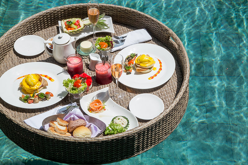 floating breakfast, a large sturdy tray in the pool containing colorful breakfast food and drinks